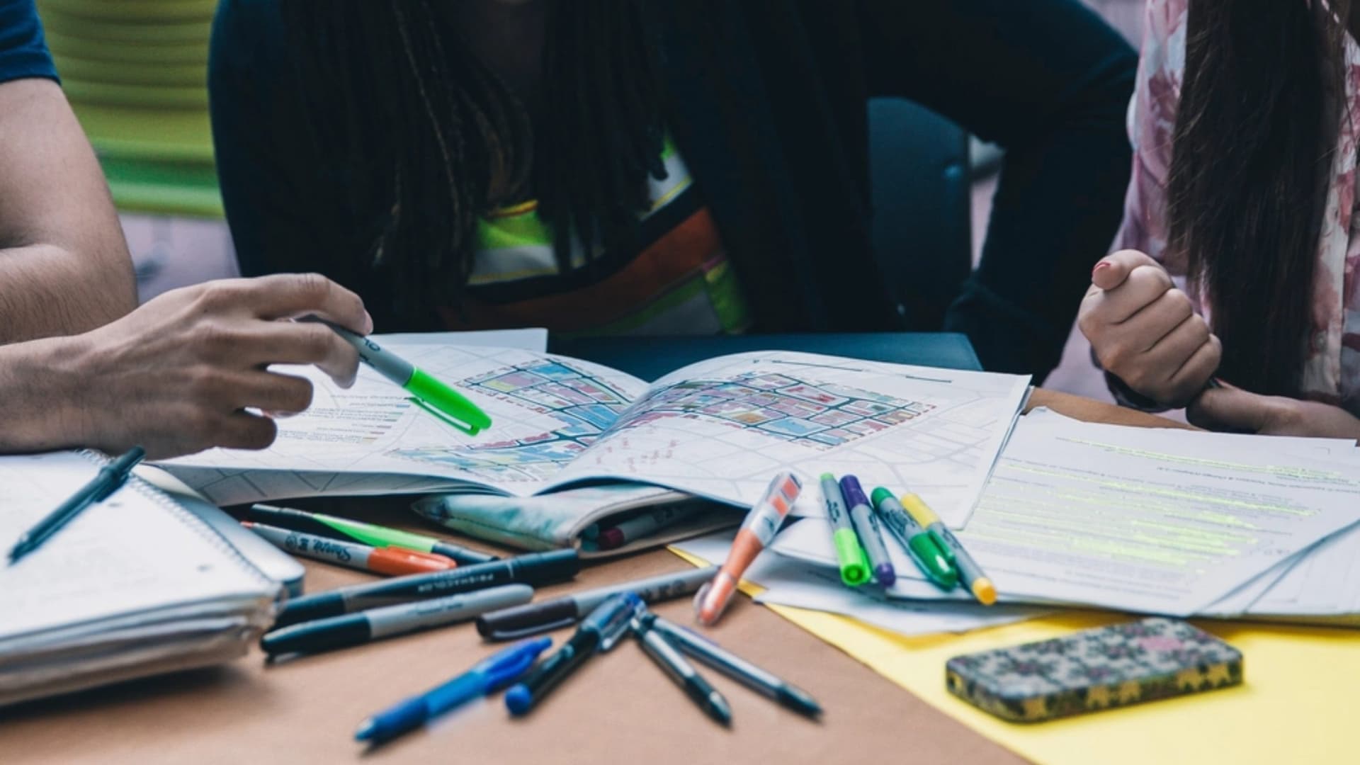 Students working together over notebooks and highlighters