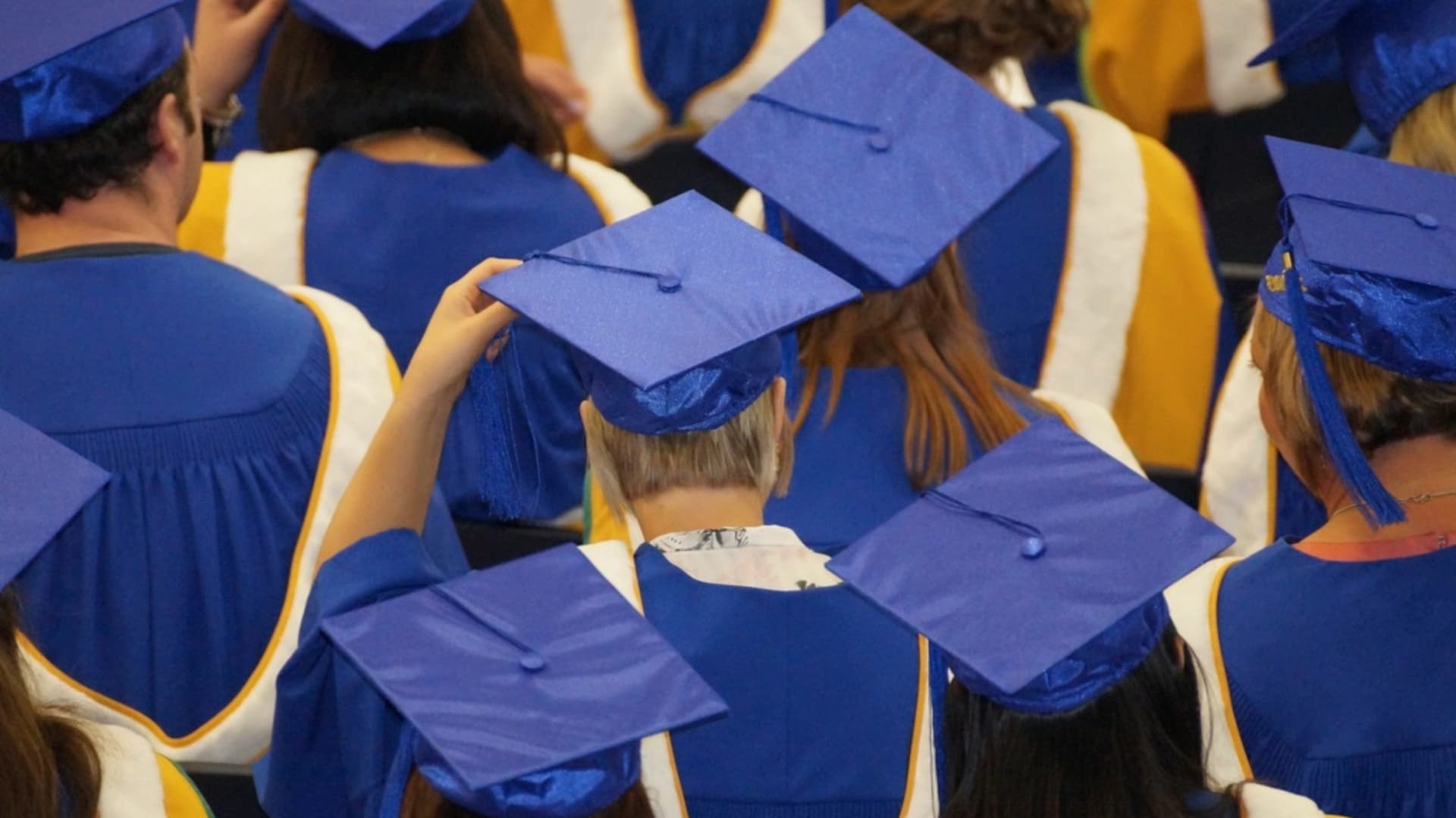 Graduates in blue caps and gowns at a graduation ceremony