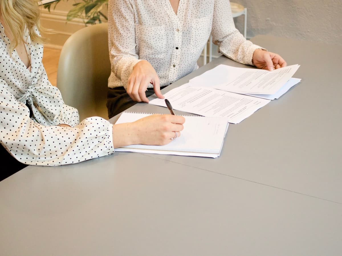 Two people reviewing application forms at a table