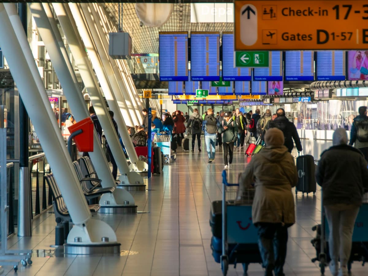 Travellers with luggage walking through an airport terminal